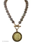 The large pendant is 1 1/2 inches in diameter, (36mm). Transparent Jonquil German Glass pendant hangs from a beautiful strand of semi-precious Gray Agate, hand-knotted. 17 inch length, 