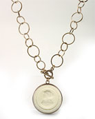 One of our most popular new necklaces, now in Ivory hand-pressed German glass intaglio. Pendant is 1 1/2 inches in diameter, chain length of 20 inches. The ivory cameo is opaque, and one of our favorite new colors. Very flattering to any skintone. Bronze.