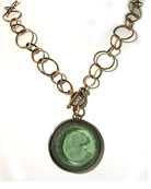 New, one of our most popular necklaces of the season, our tourmaline German glass intaglio on chain. Wonderful new chain measures 20 inches in length. Large pendant is 1 1/2 inch in diameter. Perfect for a suit, sweater or blouse, very versatile and wearable. Bronze. Call or email for other colors.