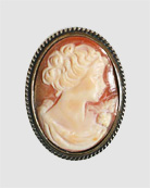 Delicate oval hand carved italian cameo pin with classical setting.  1 1/4 by 1 inches in size. Shown in our signature bronze metal. Made to order in the U.S.A.